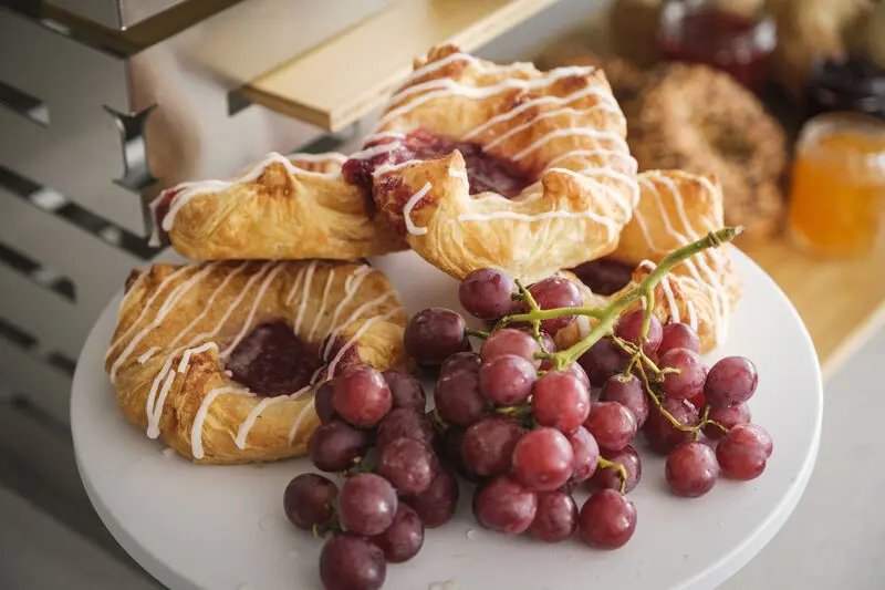 Assorted danish pastries on plate with grapes